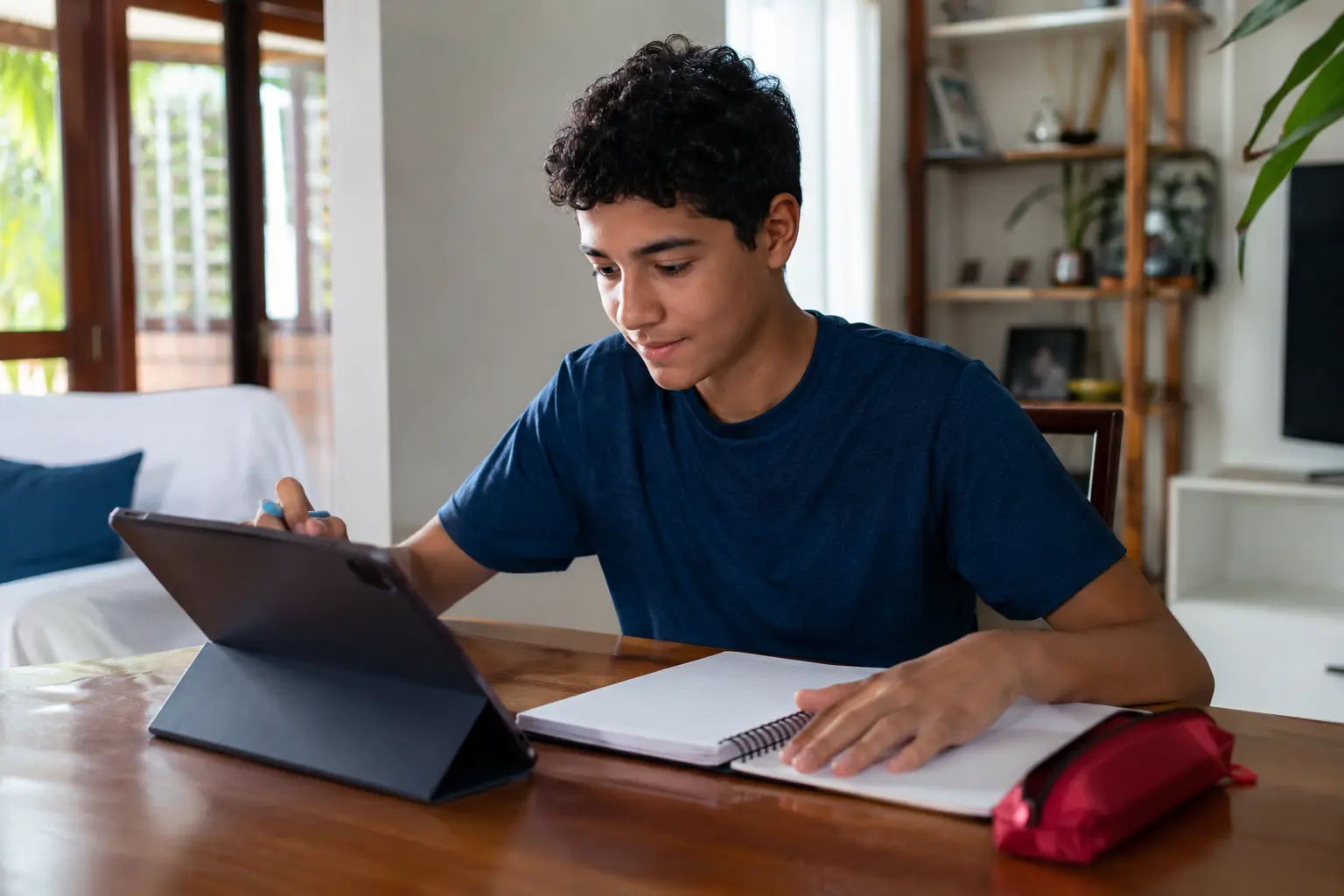 Estudante usando tablet e caderno